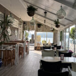 Decoración interior con plantas colgantes y vistas al mar