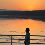 Niño observando el atardecer junto al mar