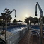 Piscina de camping con duchas y vistas al mar