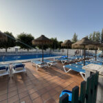 Piscina exterior con hamacas y sombrillas